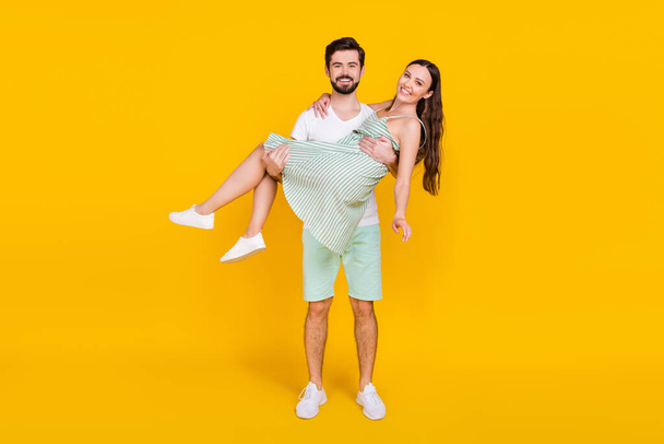 Photo of couple in love reliable bearded man hold girlfriend wear casual outfit isolated yellow color background - Valokuva, kuva
