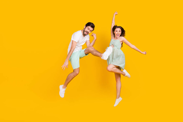 Photo of crazy careless couple rejoice win attainment wear casual outfit isolated yellow color background - Zdjęcie, obraz