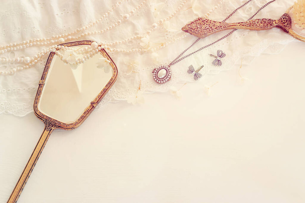 Background of white delicate lace fabric, pearls and vintage hand mirror - Foto, Imagem