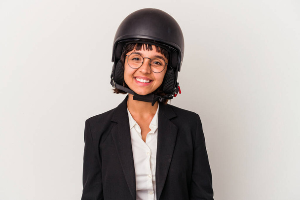 Joven mujer de negocios de raza mixta con un casco de moto aislado feliz, sonriente y alegre. - Foto, imagen