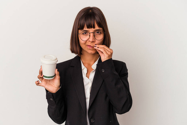 Young mixed race business woman holding a coffee isolated on white background with fingers on lips keeping a secret. - Foto, immagini