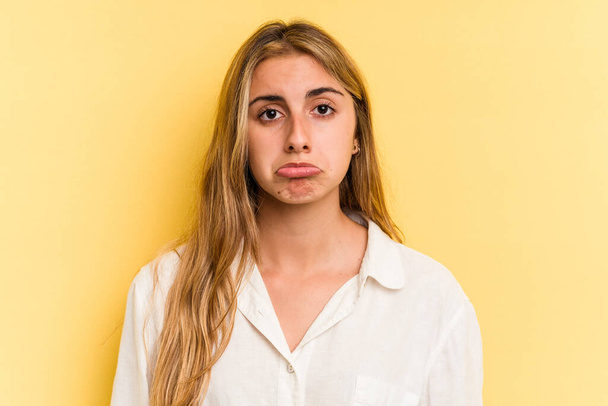 Giovane donna bionda caucasica isolata su sfondo giallo triste, faccia seria, sentirsi infelice e dispiaciuta. - Foto, immagini