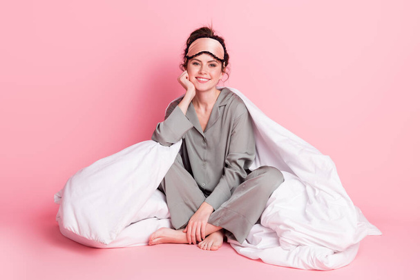 Full body photo of young girl happy positive smile sit floor cover blanket wear pajamas isolated over pink color background - Foto, afbeelding