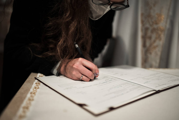γυναίκα υπογράφει ένα πιστοποιητικό γάμου στην ιερή λειτουργία - Φωτογραφία, εικόνα