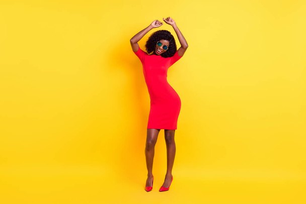 Full length photo of shiny sweet dark skin lady dressed red outfit glasses dancing isolated yellow color background - Photo, image