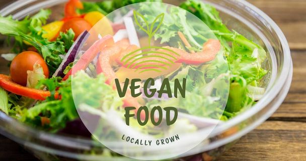 Close-up of vegan food locally grown symbol text against fresh salad in bowl. digital composite of healthy food and sign. - Foto, Imagen