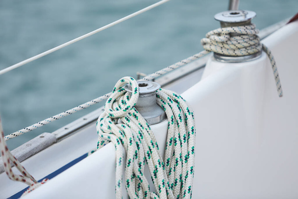 Winch and nautical ropes on a sailing boat in the port - Фото, изображение