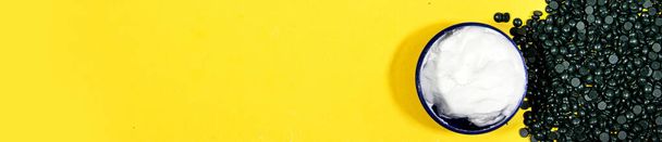 депіляційна перламутрова синя тверда воскова квасоля та кремова коробка для обличчя або тіла на жовтому фоні
 - Фото, зображення