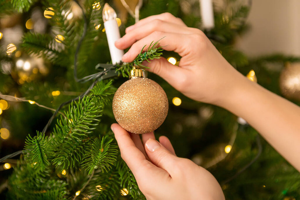 Close up of woman decorating tree for christmas - Foto, Imagen