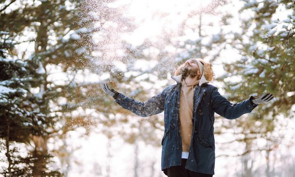 Portrait de jeune homme dans une forêt enneigée d'hiver. Saison, Noël, voyage et concept de personnes. - Photo, image