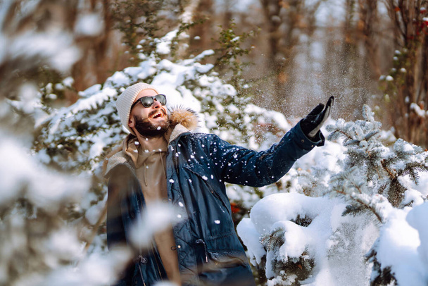 Portrait of  young man  in snowy winter forest. Season, christmas, travel and people concept. - Foto, Imagem