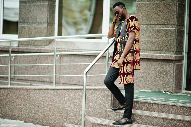 African stylish and handsome man in traditional outfit and sunglasses standing outdoor. - Φωτογραφία, εικόνα