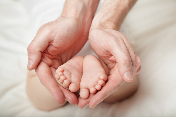 Babyfüße in die Hände des Vaters gelegt - Foto, Bild