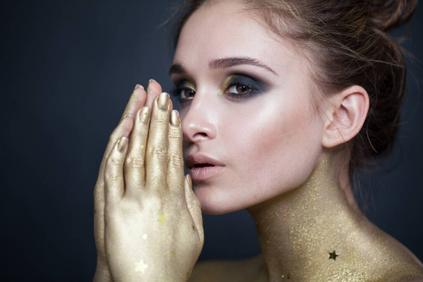 Beautiful glamorous woman with makeup and hands near face on dark background - Foto, immagini