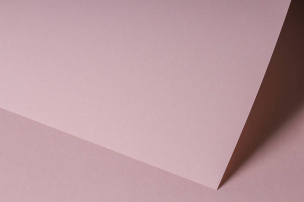 Blank pastel pink paper sheet card note with shadows. Abstract geometric monochrome pink background with copy space for text. Front diagonal view - Fotó, kép