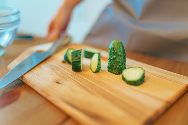 Woman slicing vegetables for salad at kitchen. Prepare healthy meal - Foto, Imagem