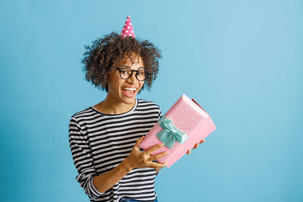 Fröhliche Frau hält Geburtstagsgeschenk in der Hand - Foto, Bild