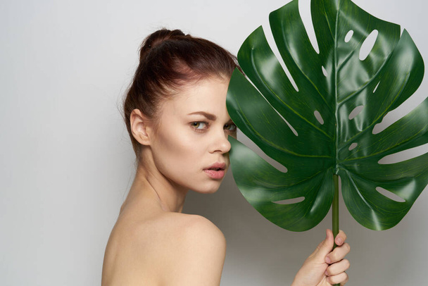 attractive woman clean skin palm leaf cosmetics studio model - Foto, Imagen