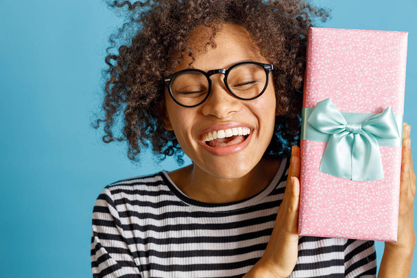 Glückliche fröhliche Frau hält Geschenkbox mit Schleife - Foto, Bild