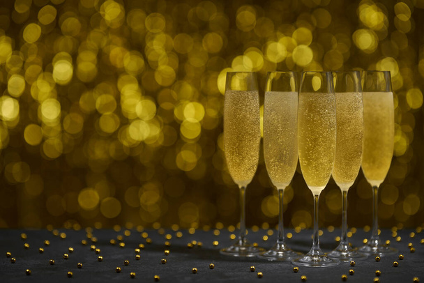 Champagneglazen op gouden achtergrond. Partij en vakantie feest concept. - Foto, afbeelding