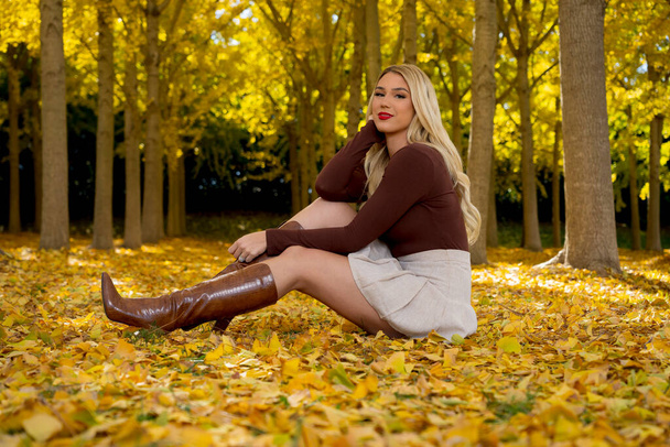 Un magnifique modèle blond pose à l'extérieur tout en profitant du temps d'automne - Photo, image
