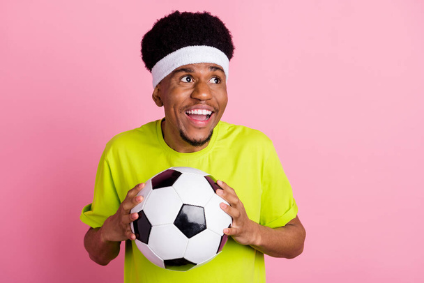 Portret atrakcyjnego wesołego faceta trzymającego piłkę grającego w piłkę nożną mecz odizolowany na różowym pastelowym tle koloru - Zdjęcie, obraz