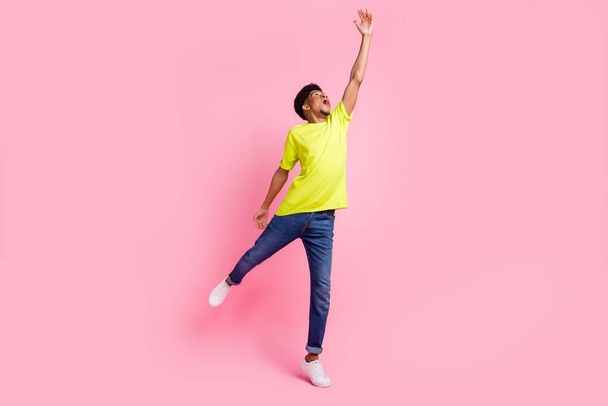 Full length φωτογραφία του νεαρού ενθουσιασμένοι αφρικανός τύπος προσπαθούν να πιάσουν ομπρέλα ματιά κενό χώρο απομονώνονται σε ροζ φόντο χρώμα - Φωτογραφία, εικόνα