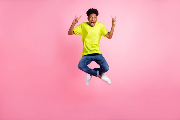 Full length body size view of attractive cheerful guy jumping showing horn symbol isolated over pink pastel color background - 写真・画像