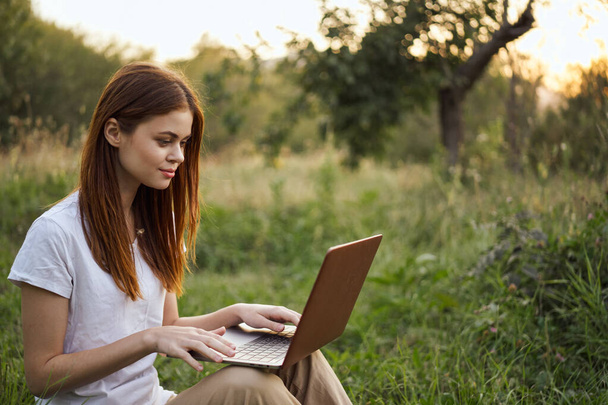 women outdoors in field with laptop leisure technology freedom - Foto, Imagen