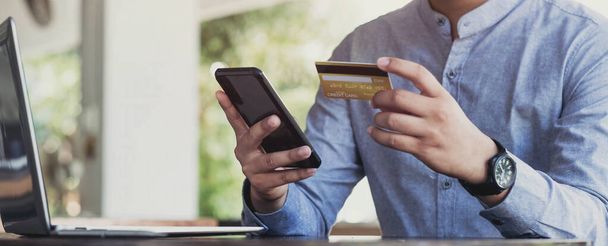 Онлайн-оплата, руки мужчины держат смартфон и используют кредитную карту для онлайн-покупок. Киберпонедельник - Фото, изображение