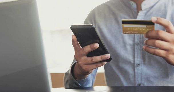 Онлайн-оплата, руки мужчины держат смартфон и используют кредитную карту для онлайн-покупок. Киберпонедельник - Фото, изображение