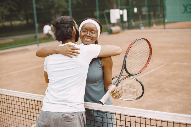 Two tennis players hugging after the match - Фото, изображение