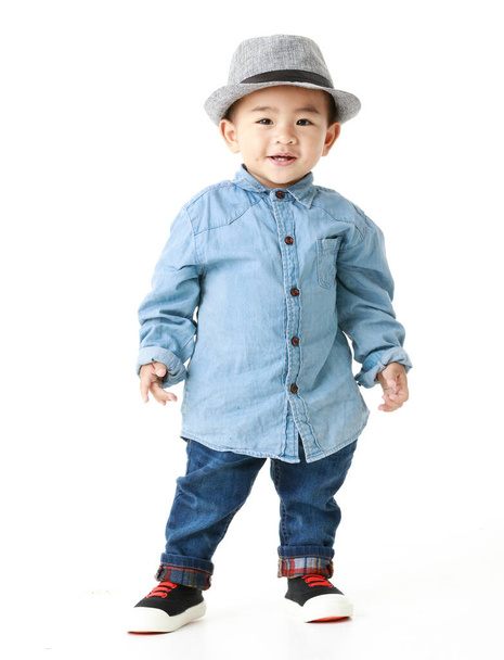 Lovely portrait of cute Asian little boy smiling on smart hat and handsome outfit with happy to play outdoors. Attractive innocent kid looks healthy, cheerfully enjoy walking as childhood lifestyle. - Foto, Imagen