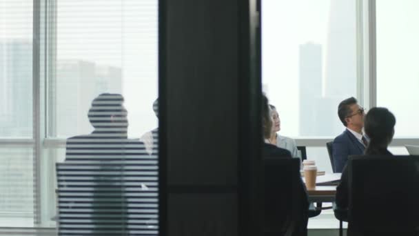 nuori aasialainen liiketoiminnan nainen puhuu aikana joukkue kokouksessa kokoushuoneessa modernin yhtiö - Materiaali, video