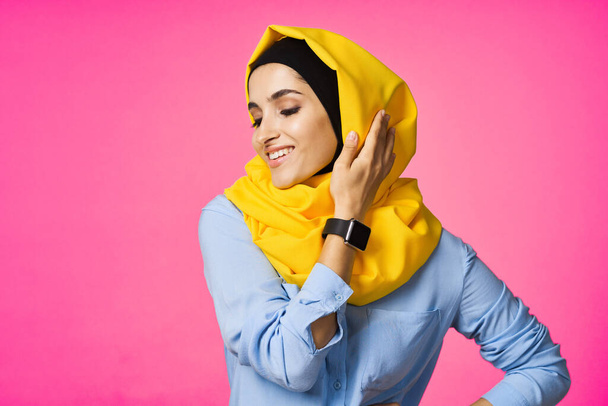 cheerful woman in yellow hijab electronic watch technology user pink background - Fotografie, Obrázek