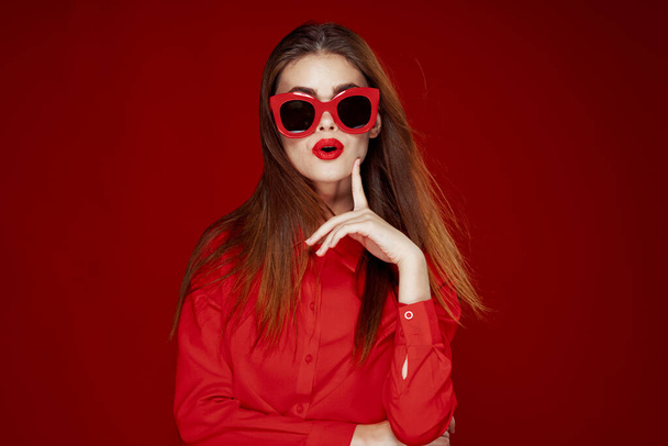attractive woman in red shirt sunglasses fashion red background - Photo, Image