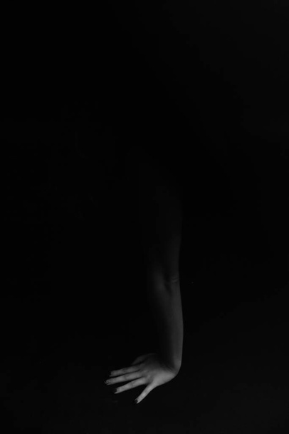 dramatický a tmavý portrét ženy, umělecká módní střelba v tmavém ateliéru, rozmazaný obraz a rozostřený obraz pohybů těla - Fotografie, Obrázek