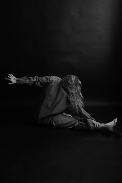 dramatic and dark portrait of a woman, art fashion shooting in a dark studio, blurred image and unfocused image of body movements - Foto, Imagem