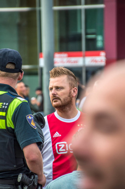 Großaufnahme eines Ajax-Anhängers und eines Polizisten in Amsterdam Niederlande 2018 - Foto, Bild