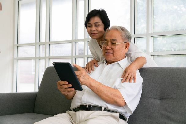 Happy senior people using digital tablet as a learning tool and spending time together, Asian Senior friends  at home. - 写真・画像
