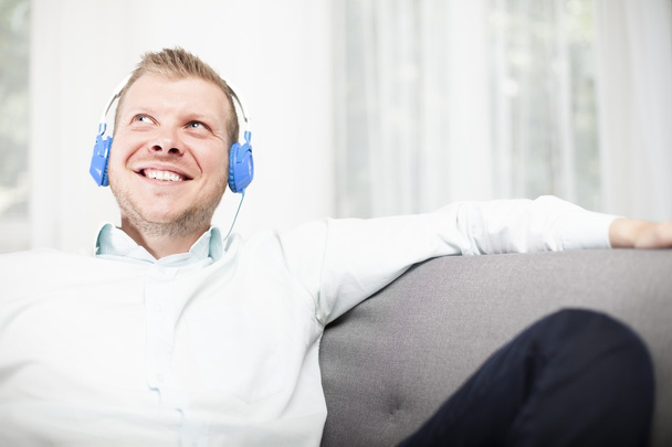 Happy man smiling as he listens to his music - Foto, Imagen