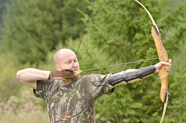 Young man training with the bow - Photo, Image