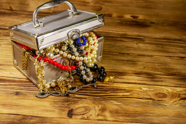 Joyero lleno de joyas y accesorios sobre fondo de madera - Foto, imagen