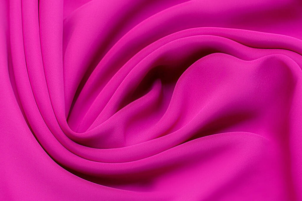 Detailní textura přírodní červené nebo růžové nebo fuchsiové tkaniny nebo látky stejné barvy. Textilní struktura z přírodní bavlny, hedvábí nebo vlny nebo lněného textilního materiálu. Červené nebo růžové nebo fuchsie textilie plátno pozadí. - Fotografie, Obrázek