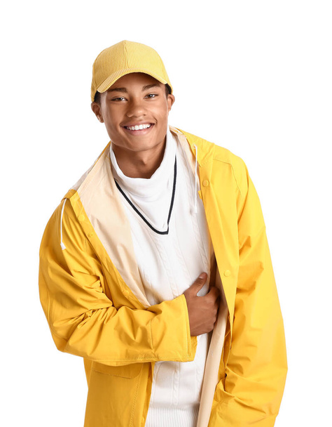 Guapo chico afroamericano con estilo en impermeable sobre fondo blanco - Foto, Imagen