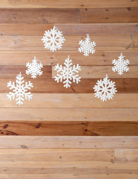 Weiße Schneeflocken hängen an Holzwand - Foto, Bild