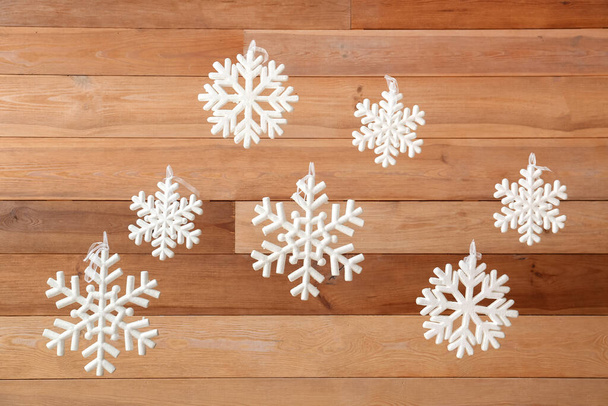 Weiße Schneeflocken hängen an Holzwand - Foto, Bild