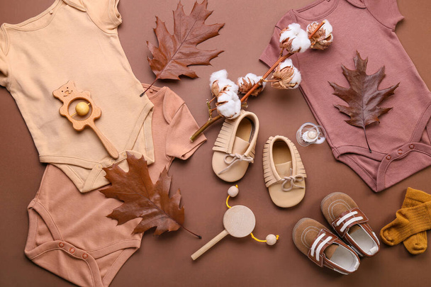 Composition with baby clothes, shoes, accessories and natural decor on color background - Photo, Image