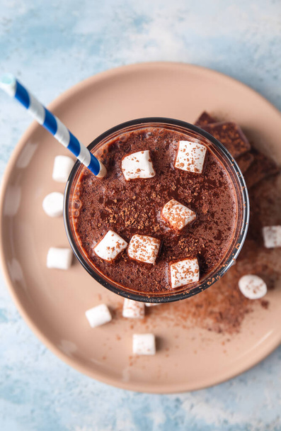 Glas leckere heiße Schokolade mit Marshmallows auf blauem Hintergrund - Foto, Bild