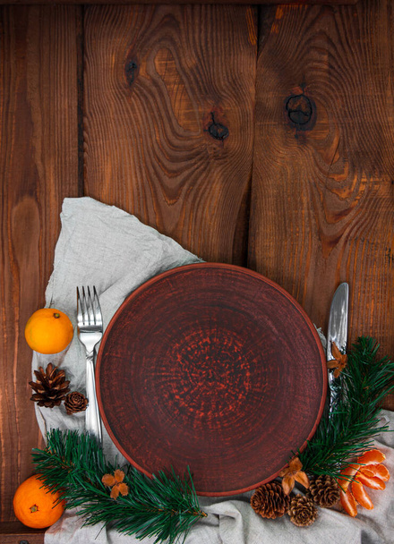 Vánoční menu stůl nastavení prázdný jíl deska jedle strom větve mandarinky slavnostní událost dekorace prádlo ubrus stolní nádobí dřevěné pozadí ležel. Rekreační vaření kulinářské pozadí horní pohled. - Fotografie, Obrázek